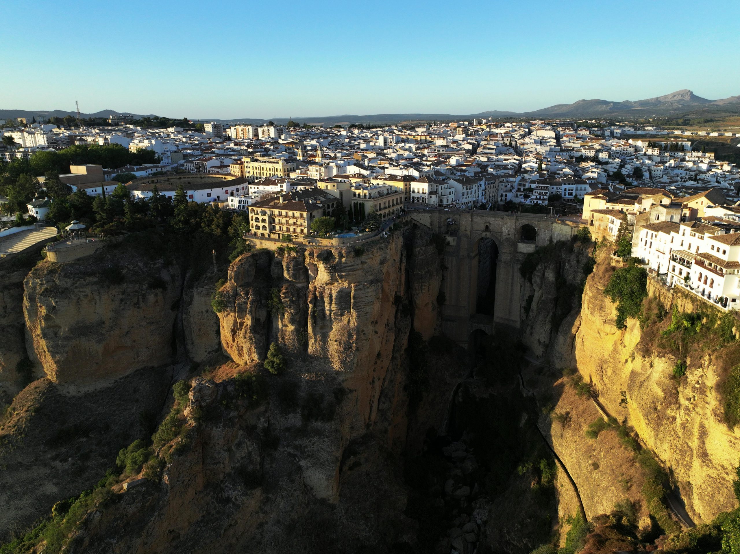 A stunning aerial view of El Tajo Gorge and Ronda's cityscape in Spain at daytime.