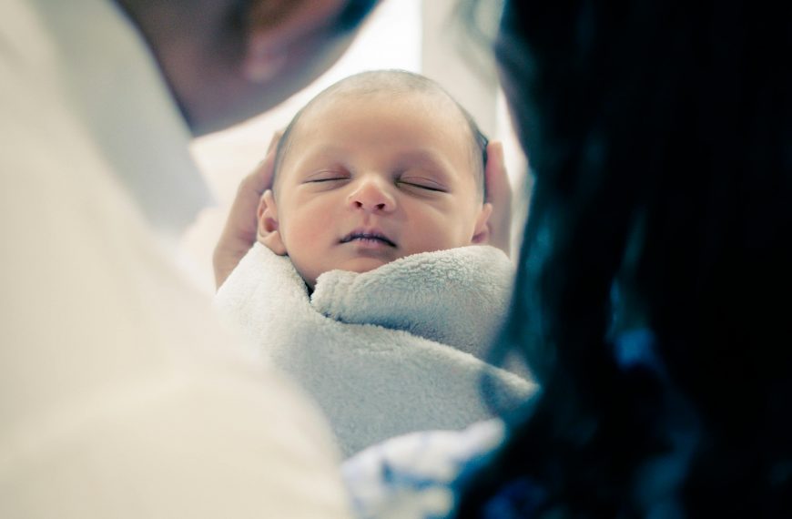 Heartwarming image of parents tenderly holding their sleeping newborn baby, wrapped in a soft blanket.
